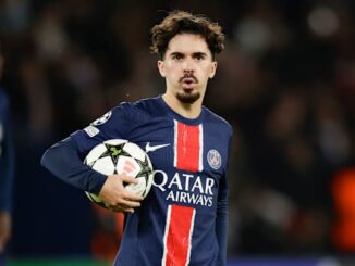Footballeur tient ballon PSG maillot domicile.