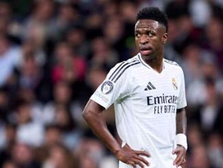Joueur de football en maillot blanc sur le terrain.