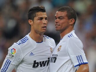 Deux footballeurs en maillot blanc sur le terrain.