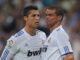 Deux footballeurs en maillot blanc sur le terrain.