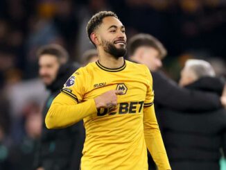 Joueur de football souriant en maillot jaune.