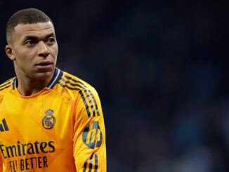 Joueur de football en maillot orange sur le terrain.