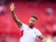 Joueur de football saluant sur le terrain.