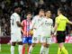 Joueurs de football discutent avec l'arbitre lors du match.