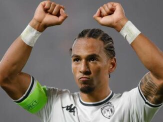Joueur de football levant les bras.
