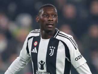 Joueur de football en action, maillot blanc et noir.