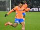 Footballeur en action sur le terrain.