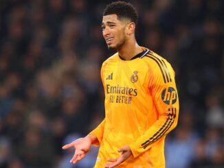 Footballeur en maillot jaune sur le terrain.