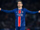 Joueur de foot en maillot bleu sur le terrain.