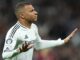 Footballeur en maillot blanc célébrant un but.