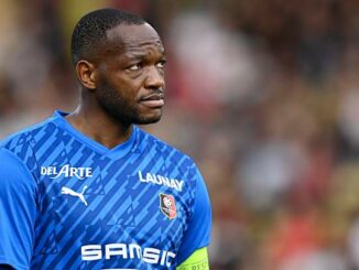 Joueur de football en maillot bleu sur le terrain.