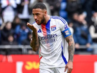 Joueur de football embrassant ses doigts sur le terrain.