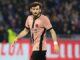 Joueur de football sur le terrain, maillot rose.