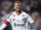 Joueur de football souriant avec maillot blanc.