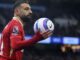 Joueur de football tenant un ballon pendant un match.