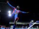 Footballeur célébrant devant le public sous les projecteurs.