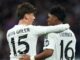 Deux joueurs de football s'enlaçant sur le terrain.