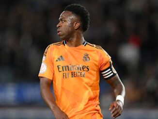 Joueur de football en maillot orange du Real Madrid.