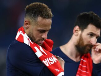 Deux joueurs de football, tristes, tenant un maillot.