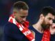 Deux joueurs de football, tristes, tenant un maillot.
