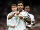 Joueur de football pointant le logo du maillot.