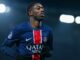 Joueur de football pendant un match, en maillot PSG.