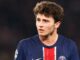 Joueur de football en maillot PSG sur le terrain.