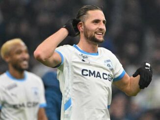 Joueur de football souriant sur le terrain.