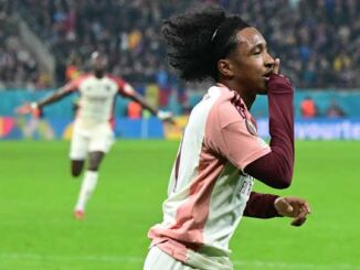 Footballeur célébrant un but sur le terrain.