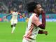 Footballeur célébrant un but sur le terrain.