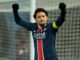 Joueur de football célébrant avec les bras levés.