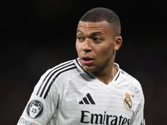 Joueur de football en maillot blanc sur le terrain.