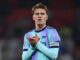 Joueur de football applaudissant sur le terrain.