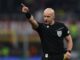 Arbitre de football pointant avec détermination durant le match.