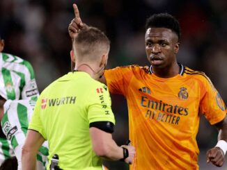 Joueur de football discutant avec l'arbitre sur le terrain.