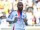 Joueur de football en maillot blanc sur le terrain.