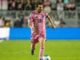 Joueur de football en maillot rose sur le terrain.