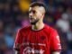 Joueur de football portant un maillot rouge.