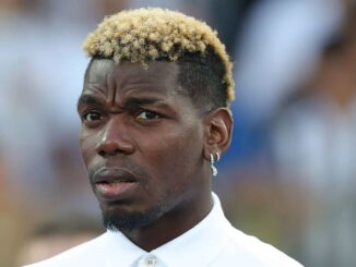 Personne avec une coiffure blonde, regardant attentivement.