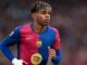 Joueur de football en maillot coloré sur le terrain.