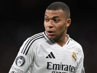 Joueur de football en maillot blanc sur le terrain.
