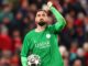Gardien de football en tenue verte tenant un ballon.