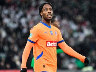 Joueur de football en maillot orange sur le terrain.