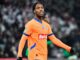 Joueur de football en maillot orange sur le terrain.