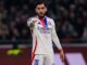Joueur de football en maillot blanc sur le terrain.