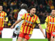 Joueurs de foot en maillots rayés jaunes et rouges.