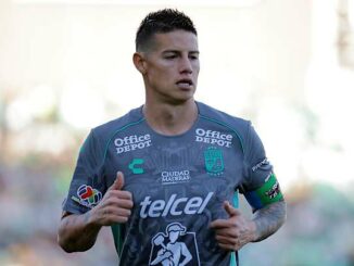 Footballeur en maillot gris sur le terrain.