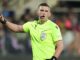 Arbitre en maillot fluorescent sur le terrain.