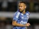 Footballeur en maillot bleu sur le terrain.