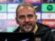 Homme souriant lors d'une conférence de presse sportive.